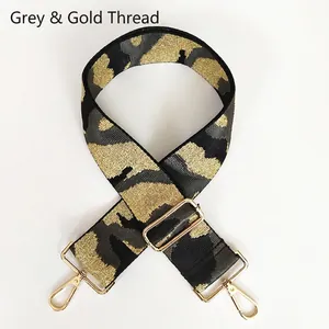 Detail of adjustable camouflage bag strap with grey and gold woven threads and hooks