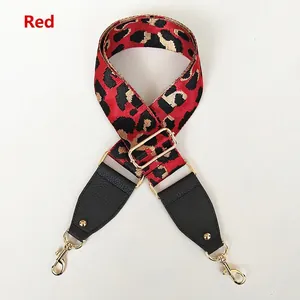 Detail of red leopard print crossbody strap with black litchi leather and gold hardware