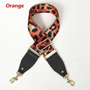 Detail of leopard print wide strap with orange highlights and gold metal lobster clasps