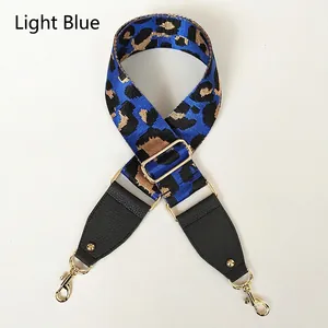 Detail of blue leopard print wide replacement strap with gold metal hooks and leather