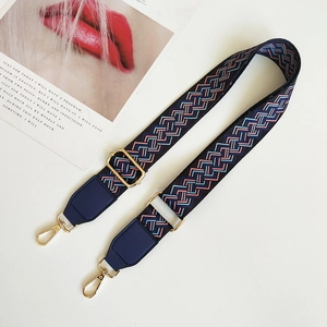Close-up of adjustable woven shoulder strap with ethnic pattern and gold metal hooks