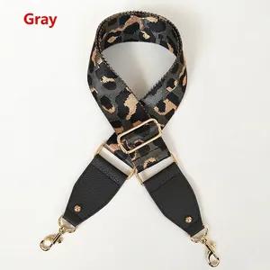Macro detail of grey leopard print bag strap with lychee leather ends and gold metal hooks