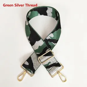 Detail view of green camo jacquard woven strap with metallic silver thread and gold hooks
