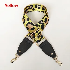 Detail of yellow leopard print crossbody strap with gold metal buckle and leather ends