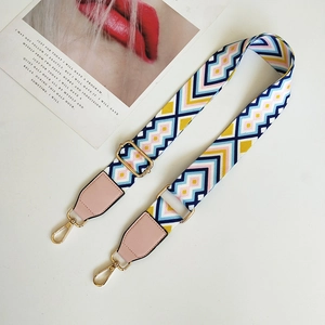 Detail of colorful geometric wave woven bag strap with pink leather and gold metal clips