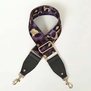 Detail of adjustable purple leopard print wide bag strap with leather ends and gold hooks