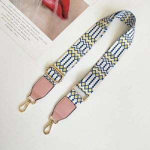 Close-up of ethnic geometric woven strap with golden hooks and pink leather accents