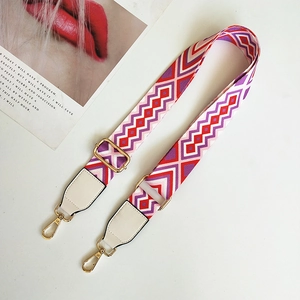 Detail of colorful geometric woven shoulder strap with white leather and gold hooks