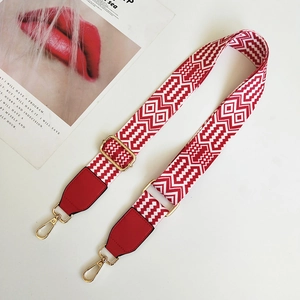 Detail of red and white ethnic woven bag strap with golden lobster clasps and buckles