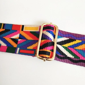 Close-up of bohemian colorful woven bag strap with golden metal buckle and geometric pattern