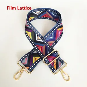 Detail view of ethnic geometric pattern canvas bag strap with golden metal lobster hooks
