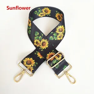 Detail of adjustable sunflower pattern canvas bag strap with gold metal swivel hooks