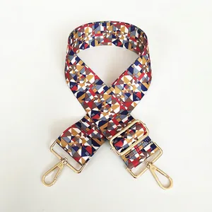 Close-up of geometric pattern canvas purse strap with gold metal lobster clasps