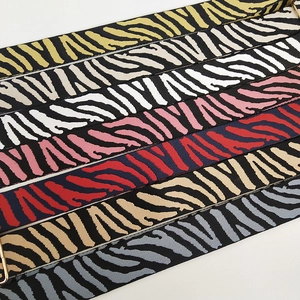 Detailed view of multi-color zebra pattern bag straps with premium gold metal hooks