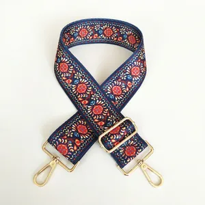 Detail of vintage ethnic floral wide canvas bag strap with golden metal lobster clasps