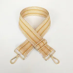 Detailansicht des gelb-weißen Stoffgurts mit geometrischem Muster und Goldkarabinern