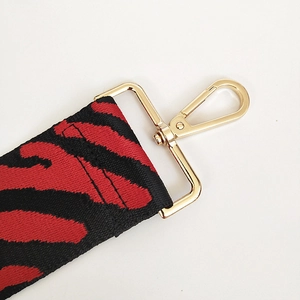Detail of red and black zebra pattern wide strap with durable golden lobster clasp