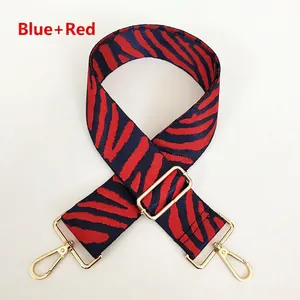 Detail of red and blue zebra pattern shoulder strap with golden metal swivel hooks