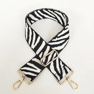 Detail of adjustable black and white zebra pattern strap with light gold alloy metal clips