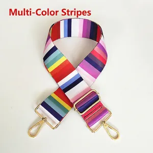 Close-up of colorful striped canvas shoulder strap with golden metal hooks and adjustable buckle
