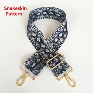 Close-up of snake print pattern canvas bag strap with golden metal swivel hooks