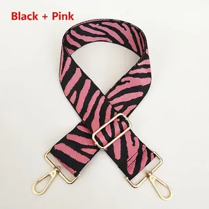 Detail of black and pink zebra pattern woven strap with polished gold lobster clasps