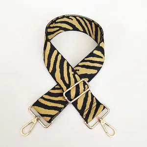 Detail of adjustable zebra pattern shoulder strap with golden metal lobster clasps