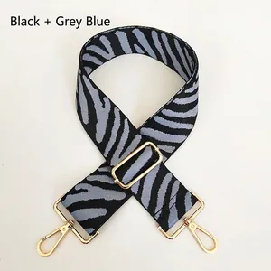 Macro shot of durable zebra pattern strap in black and grey-blue with gold metal hooks