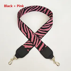 Detail of pink and black zebra pattern wide strap with golden lobster clasps