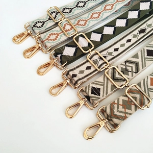 Detailed view of adjustable wide embroidered bag straps with golden metal hooks