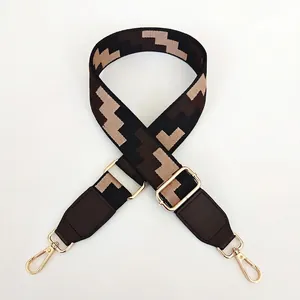 Detail of adjustable wide fabric strap with black geometric pattern and gold hooks
