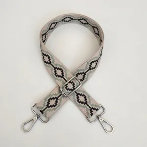 Detail of adjustable geometric embroidery bag strap with silver metal swivel hooks