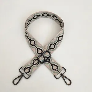 Detail of adjustable thick fabric bag strap with diamond pattern and gunmetal hooks