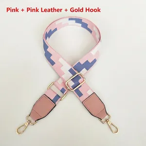 Detailed view of adjustable pink woven bag strap with golden metal hooks and leather trim