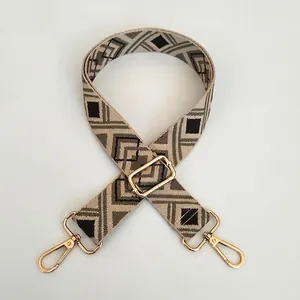 Close-up of adjustable embroidered purse strap with golden metal hooks and geometric patterns