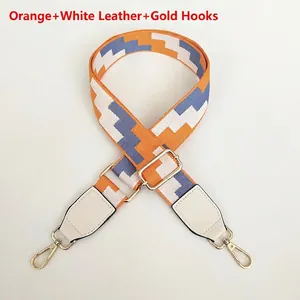 Close-up of adjustable embroidered strap with orange wave pattern and gold metal hooks