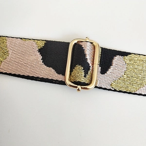 Close-up of jacquard camouflage bag strap with light gold adjustable metal buckle