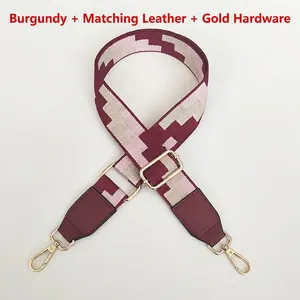 Detail of burgundy embroidered bag strap with golden swivel hooks and leather trim
