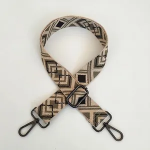 Close-up of diamond pattern jacquard woven strap with matte black metal swivel hooks