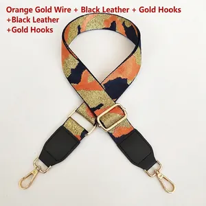 Close-up of orange and gold jacquard embroidered wide bag strap with golden metal hooks