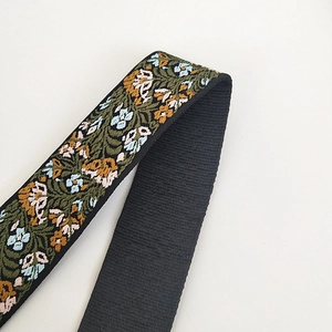 Close-up of floral embroidery on wide shoulder strap with orange and blue flowers