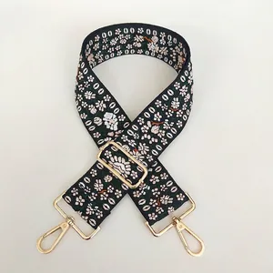 Detail of floral embroidered wide purse strap with high-quality golden metal hooks