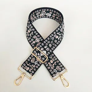 Detail view of ethnic floral embroidered bag strap with adjustable golden hooks