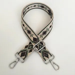 Detail of adjustable geometric diamond embroidered bag strap with silver metal hooks