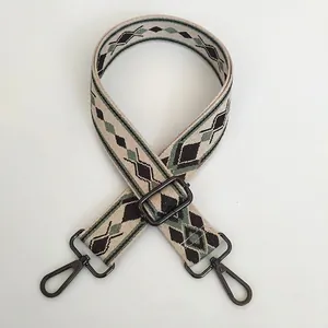 Close-up of adjustable woven purse strap with green and black geometric diamond patterns