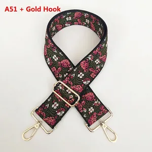 Close-up of floral embroidery on wide shoulder strap with gold metal hooks and details