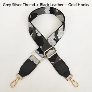 Adjustable silver-grey camo woven strap with black leather ends and gold metal buckles