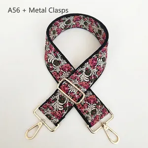 Detail of floral embroidery on wide bag strap with gold lobster clasps and buckle