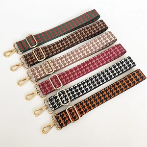 Detailed view of colorful houndstooth embroidered wide bag straps with gold metal buckles