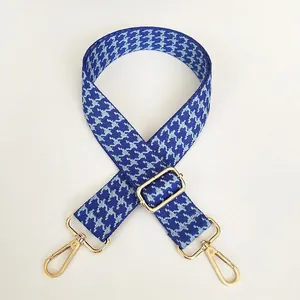 Close-up of blue houndstooth wide bag strap with adjustable gold alloy buckle and metal clip